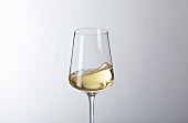 Schwappender Weißwein im Glas