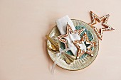 Decorated gingerbread stars and silver cutlery on plate as table decorations