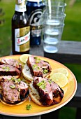 Duck breast on slices of toast with beer and glasses in the background