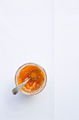 Apricot jam in a glass with a spoon