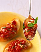 Bruschetta und Löffel mit Tomaten, Zwiebeln und Basilikum