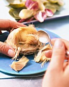 An artichoke heart being removed