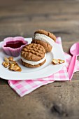 Peanut butter ice cream sandwiches with red berry sauce and peanut brittle