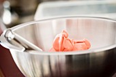 Pink meringue for making macaroons in a mixing bowl