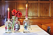 Festive motifs stuck on old glass bottles used as candlesticks