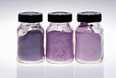 Small jars of purple make up