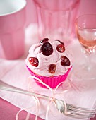 A cupcake with dried cherries, cranberries and cherry butter cream