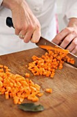 A chef dicing carrots