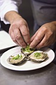 Oysters being garnished