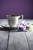 A cup of coffee and pansies