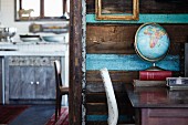 Globe on desk next to open doorway with view into kitchen