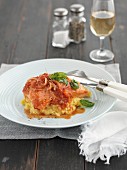 Steamed salmon with tomato sauce and fried basil on polenta