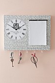 Hand-crafted key hanger with clock and notepad mounted on pink wall