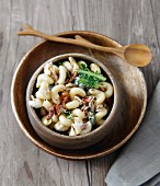 Macaroni salad with dried tomatoes, lettuce, bacon and shallots