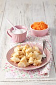 Leniwe (Polish quark dumplings) with buttered crumbs, sugar and a carrot salad