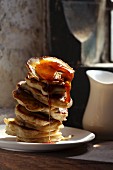 A stack of pancakes dripping with maple syrup