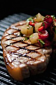 A grilled pork chop with a pineapple and chilli salsa