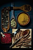 Various spices on wooden spoons and in wooden bowls
