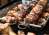 Stuffed mushrooms and figs wrapped in bacon on a grill