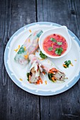Rice paper rolls filled with vegetables and tsukune served with chilli sauce (Asia)