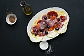 Spicy citrus fruit salad with blood oranges, citrons, onions and olives