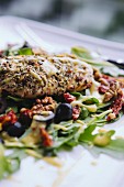 Grilled chicken on a rocket salad with dried tomatoes, olives and walnuts