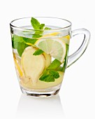Ginger tea with fresh ginger, mint and lemon in a glass cup
