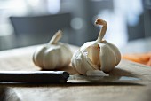 Bulbs of garlic with a knife on a chopping board