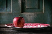 A red apple on a traditional English porcelain plate