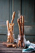 Freshly baked homemade bread sticks in glasses on a wooden table