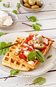 Spicy potato waffles with tomatoes, olives and feta cheese