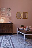 Children's room with old terrazzo floor, antique chest of drawers and dolls on modern bed