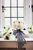 Brautstrauss mit weissen Rosen & schwarz-weißem Schleifenband auf Fensterbank