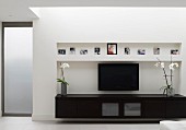 Schwarzes Lowboard und Flachfernseher in Wandnische in zeitgenössischem Wohnzimmer