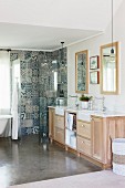 Washstand with vintage-style taps and ornamental tiles in shower area in bathroom