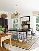 Dark wooden table, Ghost chairs and Persian rug in eclectic dining room
