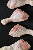 Four raw chicken drumsticks (seen from above)