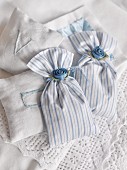 Fabric, scented sachets decorated with satin flowers and embroidered with initials