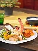 A seafood platter with a wasabi dip and a papaya salad