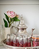 Silver teapot, Oriental tea glasses and peony in vase on tray