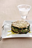 Spicy pancake cake with spinach, peas, mushrooms and cheese