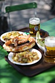 Supper and glasses of beer on a tray on a table in a beer garden (Germany)