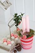 Weihnachtliches Kerzengesteck in Glas verziert mit rot-weissen Bändern
