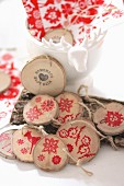 Garland of wooden discs stamped with red festive motifs