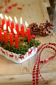 Christmas arrangement of red candles and baubles