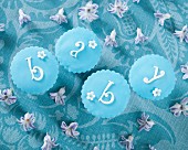 Four pastel-blue cupcakes spelling the word 'baby'