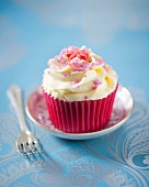 Vanilla cupcake with pink sugar and fondant flowers