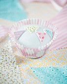 A cupcake decorated with fondant bunting