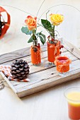 Roses in glass vases decorated with orange felt covers