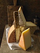 Various types of cheese on a wooden board with a knife